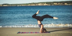Woman practicing yoga on the beach