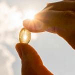 Vitamin d capsule being held up to sunlight