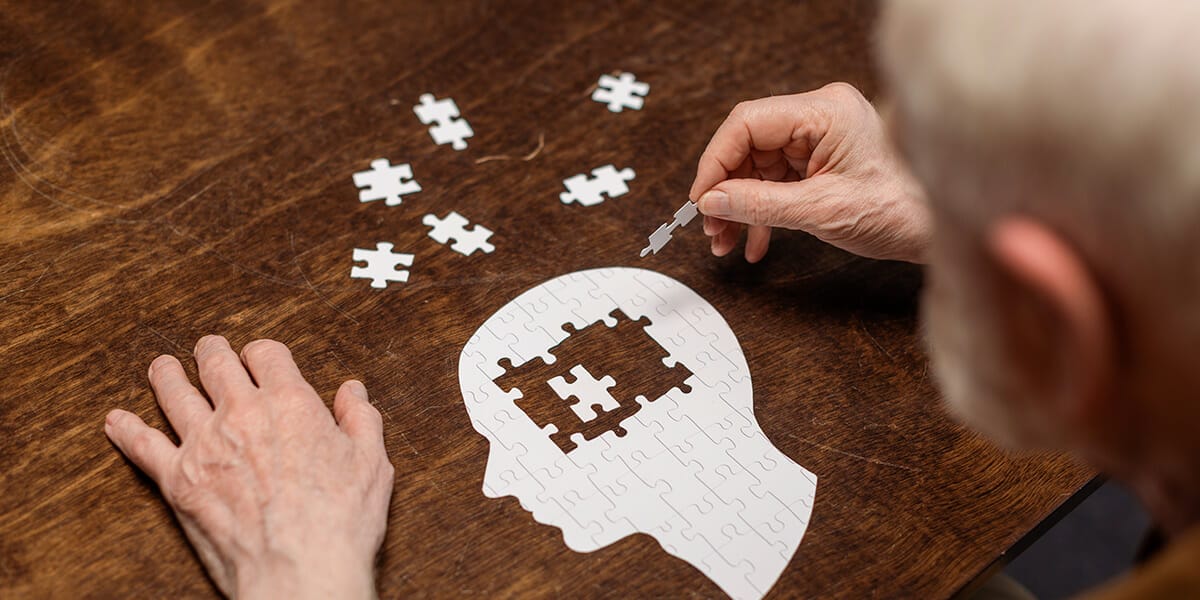 Elderly man putting together a brain puzzle