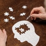 Elderly man putting together a brain puzzle